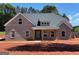 New construction featuring a gray brick exterior, covered front porch and professionally landscaped yard at 1705 Lake Dow Rd, Mcdonough, GA 30252