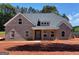 New construction featuring a gray brick exterior, covered front porch and professionally landscaped yard at 1705 Lake Dow Rd, Mcdonough, GA 30252