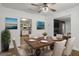 The dining room has a wooden table, six cream chairs and views of the kitchen and living room at 5180 Ash St, Forest Park, GA 30297