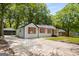 Charming single-story home features a concrete driveway, gray siding, and vibrant orange window shutters at 5180 Ash St, Forest Park, GA 30297