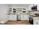 Modern kitchen with white cabinets, marble backsplash, stainless steel appliances, and butcher block shelves at 5180 Ash St, Forest Park, GA 30297