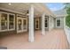 Covered back porch with wooden flooring, ceiling fan, and sturdy support columns at 115 Edgewood Pkwy, Fayetteville, GA 30215