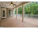 Covered back porch with wooden flooring and ceiling fan overlooking the yard at 115 Edgewood Pkwy, Fayetteville, GA 30215