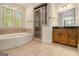 Bright bathroom with a soaking tub, shower, and granite vanity with updated light fixtures at 115 Edgewood Pkwy, Fayetteville, GA 30215