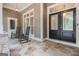Inviting front porch with stone flooring, rocking chairs and a stylish front door at 115 Edgewood Pkwy, Fayetteville, GA 30215
