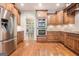 A modern kitchen features wood cabinetry, stainless steel appliances, and an open doorway at 115 Edgewood Pkwy, Fayetteville, GA 30215