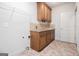 Laundry room with tile flooring, wooden cabinets, granite countertops, and a utility sink at 115 Edgewood Pkwy, Fayetteville, GA 30215