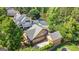 Lovely aerial view of tan two-story house with gray roof, mature trees and a picturesque pond, providing privacy at 3007 Brush Arbor Xing, Mcdonough, GA 30252