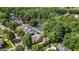 Desirable aerial view of tan home with gray roof in a lush, wooded area next to a serene pond, offering a quiet retreat at 3007 Brush Arbor Xing, Mcdonough, GA 30252