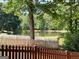 Scenic backyard view of a tranquil pond framed by a white picket fence, offering a serene natural ambiance at 3007 Brush Arbor Xing, Mcdonough, GA 30252