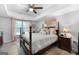 Bedroom featuring wood poster bed, natural light, wood floors, and ceiling fan at 3007 Brush Arbor Xing, Mcdonough, GA 30252