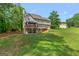 A view of the backyard that has covered decks, a verdant lawn, and mature trees, creating a serene outdoor space at 220 Drumcliff Ct, Tyrone, GA 30290
