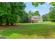 Vast backyard showcasing a well-maintained lawn, mature trees and home with a deck at 220 Drumcliff Ct, Tyrone, GA 30290