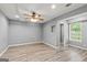 Bedroom featuring gray walls, ceiling fan, trim, and a window for natural light at 220 Drumcliff Ct, Tyrone, GA 30290