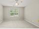 Neutral-toned bedroom featuring a ceiling fan and large window at 220 Drumcliff Ct, Tyrone, GA 30290