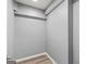 A simple walk-in closet space featuring wood-look vinyl flooring and neutral paint for a clean, modern look at 220 Drumcliff Ct, Tyrone, GA 30290