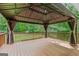 Expansive outdoor deck with a covered gazebo featuring curtains, offering a shaded view of the surrounding greenery at 220 Drumcliff Ct, Tyrone, GA 30290