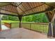 A covered deck with ambient lighting, draped curtains, and a view of the expansive and verdant backyard at 220 Drumcliff Ct, Tyrone, GA 30290
