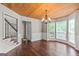 Dining room with hardwood floors, wooden ceiling, and large windows, adjacent to the staircase at 220 Drumcliff Ct, Tyrone, GA 30290