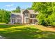 Charming two-story home with stone and vinyl siding, red shutters, a green lawn, and mature landscaping at 220 Drumcliff Ct, Tyrone, GA 30290