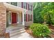 Close-up of the home's entry with a red door, white trim, and green bushes at 220 Drumcliff Ct, Tyrone, GA 30290