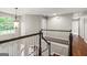 Bright hallway with hardwood floors, chandelier, and white railing at 220 Drumcliff Ct, Tyrone, GA 30290