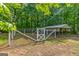 View of fenced in pen and metal horse shelter in wooded backyard at 220 Drumcliff Ct, Tyrone, GA 30290