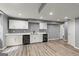 Basement kitchenette with sleek white cabinetry and modern black appliances at 220 Drumcliff Ct, Tyrone, GA 30290