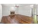 Spacious living room with hardwood floors, a stone fireplace, a ceiling fan, and natural light at 220 Drumcliff Ct, Tyrone, GA 30290