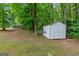 View of the property's yard, featuring a storage shed, trees, and plenty of space for various activities at 220 Drumcliff Ct, Tyrone, GA 30290