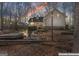 Evening view of the backyard featuring a hot tub, fire pit, and cozy seating area at 595 S Antioch Rd, Mcdonough, GA 30252