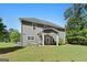 Expansive backyard showing a two-story home with a covered patio and well-maintained lawn at 130 Edgewater Trl, Fayetteville, GA 30215