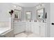 Bright bathroom featuring dual sinks with white cabinetry and framed mirrors with updated lighting at 130 Edgewater Trl, Fayetteville, GA 30215