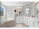 Bright bathroom with a soaking tub, tile surround, and dual sinks at 130 Edgewater Trl, Fayetteville, GA 30215