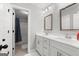 Bathroom featuring double sinks with white cabinetry, framed mirrors, and a tub/shower combo at 130 Edgewater Trl, Fayetteville, GA 30215