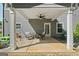 Cozy covered patio features two comfortable chairs, a ceiling fan, and access to the backyard at 130 Edgewater Trl, Fayetteville, GA 30215