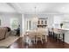 Open-concept dining area with hardwood floors, a stylish light fixture, and views of the kitchen at 130 Edgewater Trl, Fayetteville, GA 30215