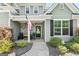 Inviting front porch with stone accents, rocking chairs, and an American flag display at 130 Edgewater Trl, Fayetteville, GA 30215