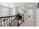 Upstairs hallway featuring a dark wood railing, light fixture, and neutral colors at 130 Edgewater Trl, Fayetteville, GA 30215