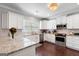 Bright kitchen featuring white cabinets, granite countertops, stainless steel appliances, and hardwood flooring at 130 Edgewater Trl, Fayetteville, GA 30215