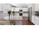 Well-lit kitchen with white cabinetry, granite countertops, stainless steel appliances, and wood floors at 130 Edgewater Trl, Fayetteville, GA 30215