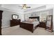 Spacious main bedroom featuring a tray ceiling, dark wood furniture, and carpeted floors at 130 Edgewater Trl, Fayetteville, GA 30215