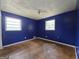 Bedroom featuring hardwood floors and two windows, with dark blue painted walls awaiting remodeling at 4274 Kimball Sw Rd, Atlanta, GA 30331