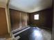 Shows a bedroom with wood paneling, damaged walls, and black and white checkered floors at 4274 Kimball Sw Rd, Atlanta, GA 30331