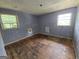 Bedroom featuring hardwood floors, peeling blue paint, and two windows, ready for a remodel at 4274 Kimball Sw Rd, Atlanta, GA 30331