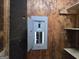Close-up of an open electrical panel on a plywood wall with shelves nearby at 4274 Kimball Sw Rd, Atlanta, GA 30331
