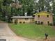 One-story brick home with a lush green lawn, mature trees, a long driveway, and yellow trim at 4274 Kimball Sw Rd, Atlanta, GA 30331