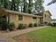 Well-kept one-story brick home with yellow trim, a small porch, and mature landscaping at 4274 Kimball Sw Rd, Atlanta, GA 30331