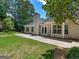 Exterior view of the backyard featuring a patio, a well-manicured lawn, and mature trees at 264 Keller Dr, Mcdonough, GA 30252