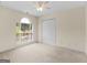 Bright bedroom featuring neutral carpet and walls, closet, and a window view of lush backyard greenery at 264 Keller Dr, Mcdonough, GA 30252